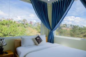ダラットにあるMây Trắng Villaの大きな窓付きの客室のベッド1台分です。