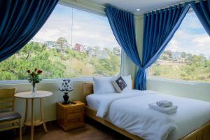 1 dormitorio con cama y ventana grande en Mây Trắng Villa, en Da Lat