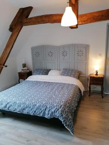 um quarto com uma cama grande e um edredão azul em LOLA em Montigny-sur-Crécy