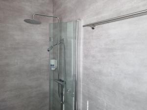 a shower with a glass door in a bathroom at Byske Gästgivargård in Byske