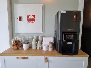 Byske Gästgivargård في Byske: كونتر مع آلة صنع القهوة وثلاجة