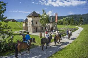a group of people riding horses down a road at Blick auf's Schloss in Itter