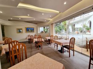 a restaurant with tables and chairs and a large window at Eco Hotel Montemerlo in Fetovaia