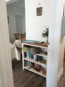 a room with a book shelf with books at Harbourlight Guesthouse in Saundersfoot