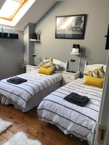 a bedroom with two beds with yellow pillows and a tv at 15 Main Street (Classic Casuals) in Letterkenny