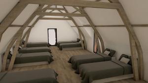 een kamer met 4 bedden in een kamer met balken bij Hoeve Ten Rooden Duifhuize in Sint-Denijs