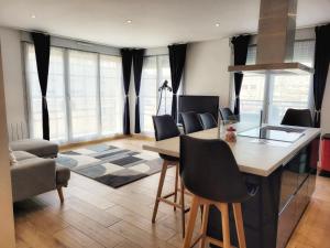 a living room with a table and chairs and windows at Chez patron T4 3BR near Disneyland and train station-Montévrain in Montévrain