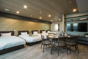 a hotel room with two beds and a table and chairs at Vacation Rent 金沢 in Kanazawa
