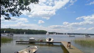 a dock with boats on a lake with boats at Domek letniskowy 36 in Giżycko
