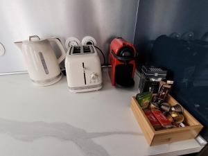 a counter top with a blender and a tea kettle at Chez patron T4 3BR near Disneyland and train station-Montévrain in Montévrain