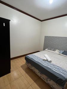 a bedroom with a bed with two white towels on it at Affordable La Union in Caba