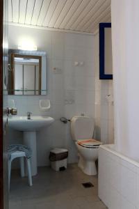 a bathroom with a sink toilet and a mirror at Saint Nicholas Hotel in Psili Ammos