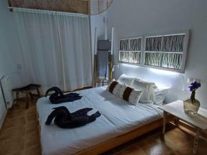 two swans sitting on a bed in a bedroom at O'Eirado Playa de Quenxe in Corcubión