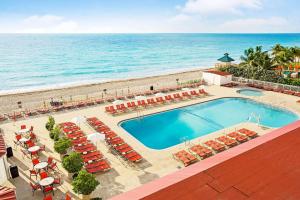 an aerial view of a resort with a swimming pool and the ocean at Ramada Plaza by Wyndham Marco Polo Beach Resort in Miami Beach