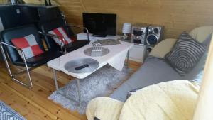uma sala de estar com um sofá e uma mesa em Domek letniskowy 36 em Giżycko