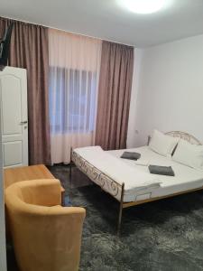 Habitación de hotel con cama y silla en Casa Sofia en Anina