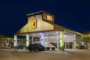 a car parked in a parking lot in front of a hotel at Super 8 by Wyndham Gulfport Biloxi Airport in Gulfport