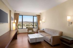 a living room with a couch and a large window at Ramada by Wyndham Jaipur North in Jaipur