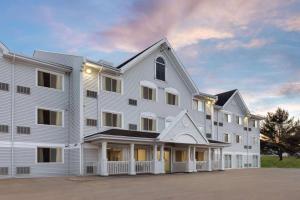 een groot wit gebouw met veel ramen bij Ramada by Wyndham Miramichi New Brunswick in Miramichi