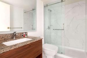 a bathroom with a shower and a sink and a toilet at Ramada by Wyndham Miramichi New Brunswick in Miramichi