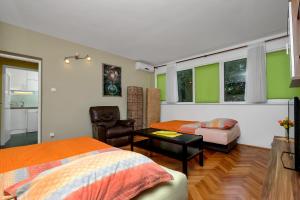 1 Schlafzimmer mit 2 Betten, einem Stuhl und einem Tisch in der Unterkunft Apartman Goranka in Makarska