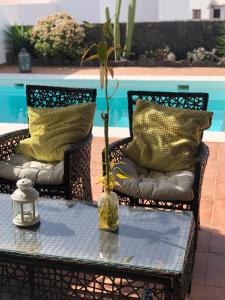 stół z dwoma krzesłami i wazon z rośliną w obiekcie Villa Tabaiba Playa Blanca Lanzarote w mieście Playa Blanca
