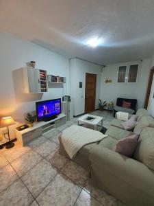 a living room with a couch and a flat screen tv at Casa El Hornillo in Puerto de Mogán