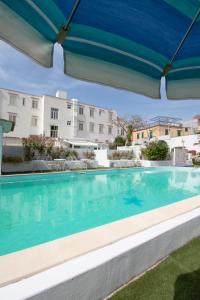 une grande piscine avec un parasol bleu dans l'établissement Hotel Stella Maris Terme, à Ischia