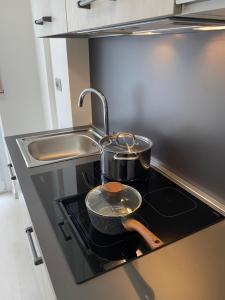 een keuken met twee potten en pannen op een fornuis bij First Home Milan in Milaan