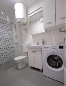 ein weißes Bad mit einer Waschmaschine und einem WC in der Unterkunft Apartment Smile in Solin