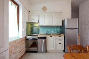モンテ・ナイにあるVilletta Splendorのキッチン(白いキャビネット、ステンレス製の冷蔵庫付)