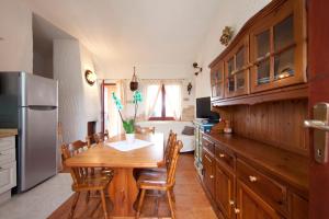 モンテ・ナイにあるVilletta Splendorのキッチン(木製テーブル、椅子、冷蔵庫付)