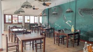 a restaurant with tables and chairs and a wall with an aquarium at Marina Village in Moalboal