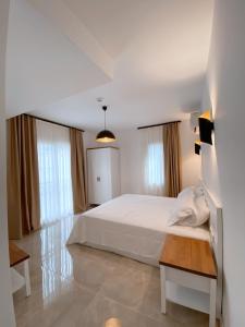 切什梅的住宿－Amber Boutique Hotel，卧室配有白色的床和2扇窗户。
