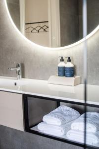 Un baño con lavabo, espejo y toallas. en Baenk designhideaway, en Nieuwpoort
