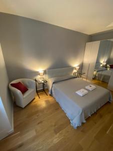 a bedroom with a white bed and a chair at Cavour Home in Rome