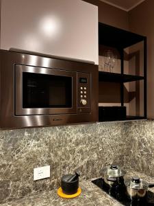 a microwave above a stove in a kitchen at DeGasperi Studio Apartment in Trani