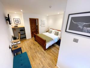 a hotel room with a bed and a picture on the wall at Ravenscraig Guest House in Aviemore