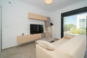 sala de estar con TV y sofá en Balcones de la Laguna, en Torrevieja