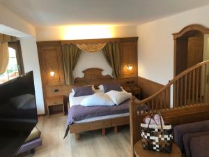 um quarto com uma cama e uma cabeceira em madeira em Cavallino Lovely Hotel em Andalo