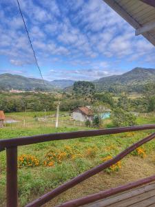 uma vista para um campo com montanhas ao fundo em Cabana Recanto do Physalis em Rio Rufino