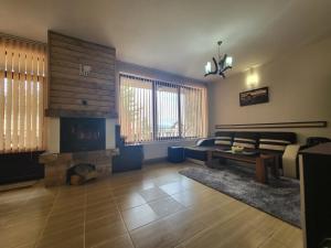 a living room with a couch and a fireplace at Ваканционна къща ,,Родопски уют " in Dospat