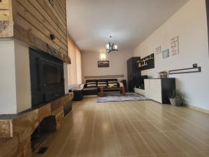 a living room with a fireplace and a table at Ваканционна къща ,,Родопски уют " in Dospat