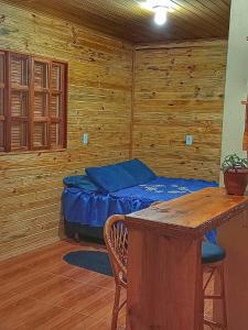 um quarto com uma cama e uma parede de madeira em Cabana Recanto do Physalis em Rio Rufino