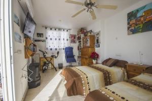 濱海羅克塔斯的住宿－Apartamento a 300m de la playa en Roquetas de Mar，一间卧室配有两张床和吊扇