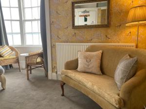 a living room with a couch and a mirror at Whitecliff Guest House in Weymouth