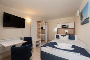 a bedroom with a bed and a desk and a computer at Aparthotel Stralsund Studios und Apartments in Stralsund