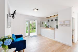 a living room with a blue couch and a kitchen at Hotel Playa Las Sinas in Villanueva de Arosa