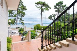 a balcony with stairs and a view of the ocean at Hotel Playa Las Sinas in Villanueva de Arosa