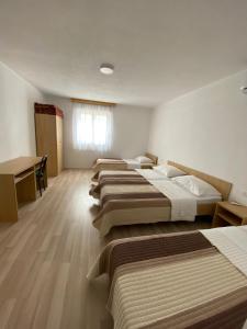 a hotel room with four beds and a desk at Pansion Maglica in Međugorje +26 photos